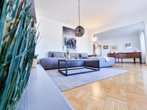 a living room with a blue couch and a table at Alpha Apartments in Essen