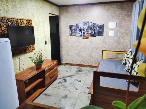 a living room with a tv and a bedroom at Sanctuary Pirenópolis Suítes e Flats in Pirenópolis