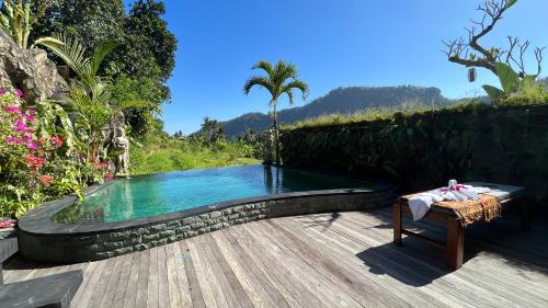 una piscina con una mesa y un banco junto a ella en Puri Jumpungan Villas en Sidemen