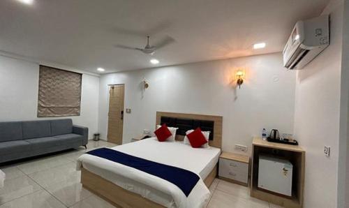 a hotel room with a bed and a couch at FabHotel Prime Anika Suites in Hyderabad