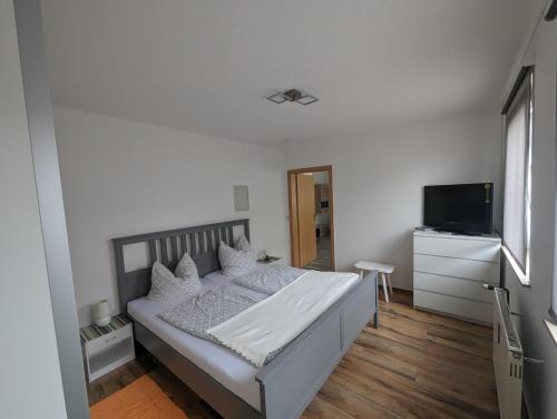 a bedroom with a bed and a flat screen tv at FEWO An der Bode in Thale