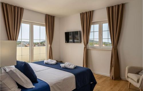 1 dormitorio con 1 cama con sábanas azules y ventanas en Villa Stina Murter, en Jezera