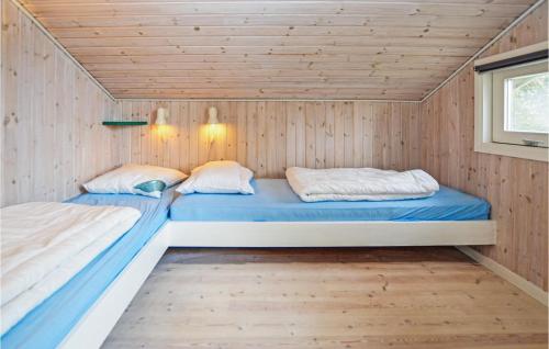 HesselagerにあるAwesome Home In Hesselager With 4 Bedrooms, Sauna And Wifiのウッドパネルの小さな部屋のベッド2台