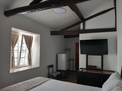 a bedroom with a bed and a flat screen tv at Quinta do Mourão in Tentúgal