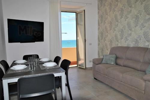 ein Wohnzimmer mit einem Tisch und einem Sofa in der Unterkunft Brezza di mare appartamento fronte spiaggia in Formia