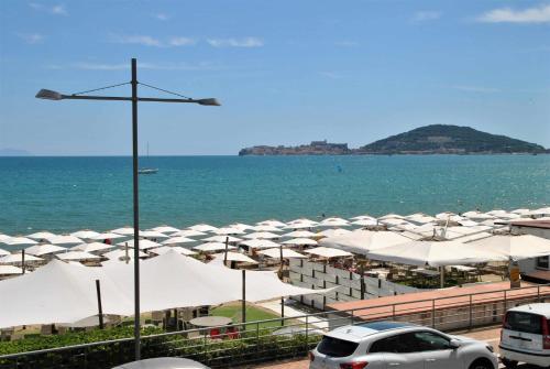 einen Strand mit weißen Sonnenschirmen und dem Meer in der Unterkunft Brezza di mare appartamento fronte spiaggia in Formia