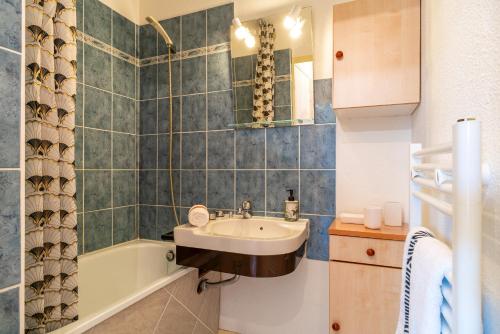a bathroom with a sink and a bath tub at Glazik - Appartement à 5 min de la plage in Saint-Nic