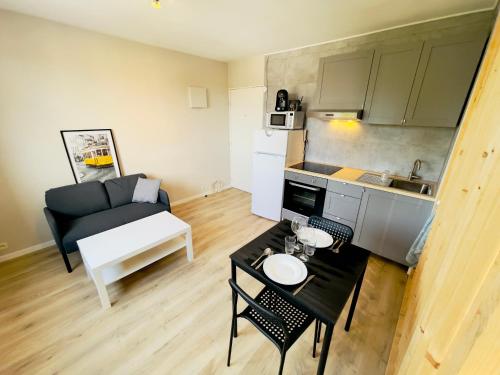 un petit salon avec un canapé et une table dans l'établissement Studio 43aJJ, à Lure