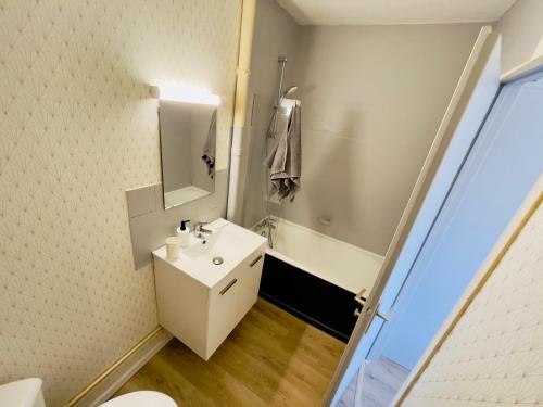 een badkamer met een witte wastafel en een spiegel bij Studio 43aJJ in Lure