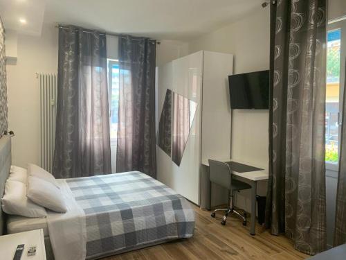 a bedroom with a bed and a desk and a window at Nibu Appartamenti - Appartamento centrale comodo a tutto in Casalecchio di Reno