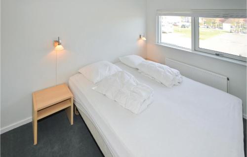 1 dormitorio con 1 cama blanca, mesa y ventana en 2 Bedroom Awesome Apartment In Ebeltoft, en Ebeltoft