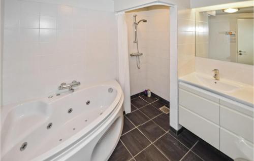Baño blanco con bañera y lavamanos en 2 Bedroom Awesome Apartment In Ebeltoft, en Ebeltoft