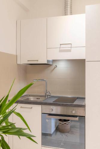 a kitchen with white cabinets and a sink at Bed E-bike in Ancona