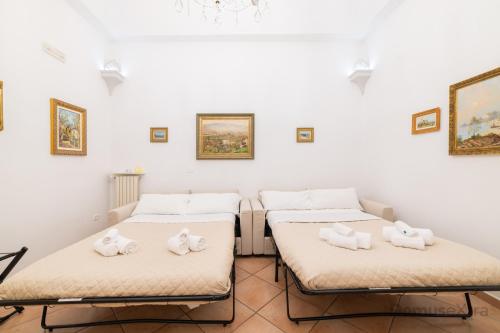 um quarto com três camas com toalhas em De Cesare53 By DomusExtra em Nápoles