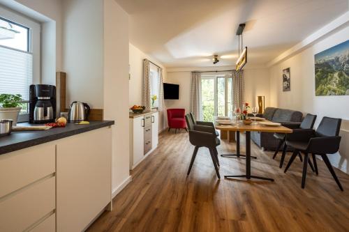 a kitchen and living room with a table and chairs at Haus Bergwelten in Bischofswiesen