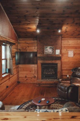 a living room with a couch and a fireplace at Great Frontier Cabin at American Heartland Cabins in Rockbridge