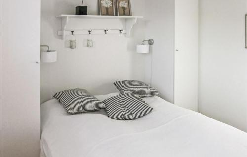 a white bedroom with two pillows on a bed at Beach Front Apartment In Bagenkop With Kitchen in Bagenkop