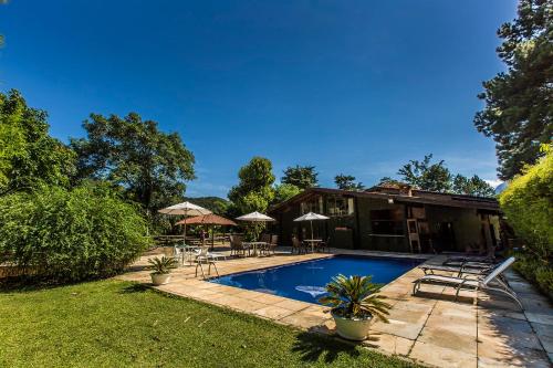 una casa con piscina en un patio en Boutique Hotel Colinas Petrópolis by Ateliê, en Petrópolis