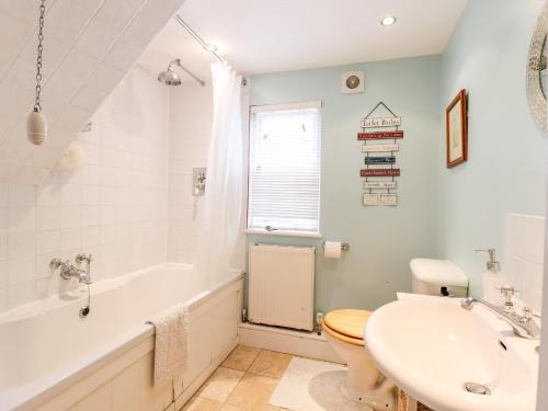 a bathroom with a tub and a toilet and a sink at 22 Church Ponds in Halstead