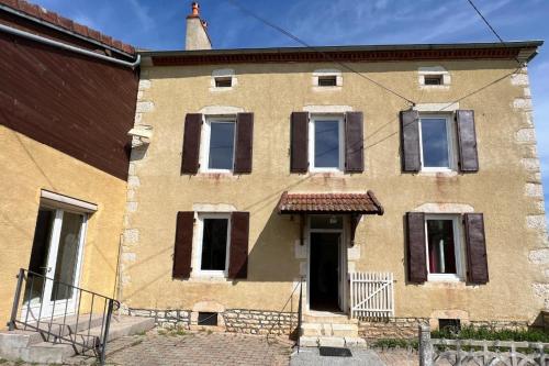 an old brick building with windows and a door at Les Gites de Louisette 1886 in Ébreuil