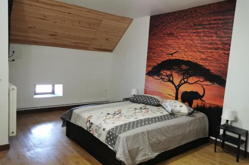 a bedroom with a bed with a painting on the wall at Les Gites de Louisette 1886 in Ébreuil