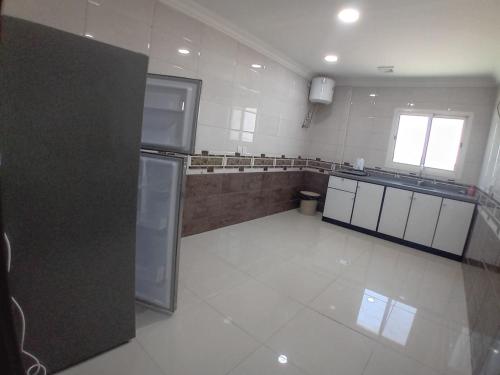 a large kitchen with a sink and a refrigerator at فندق 7c in Al Hofuf