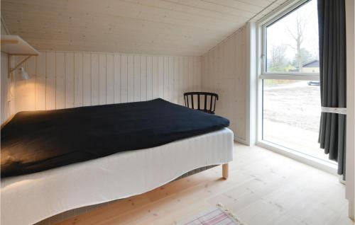 エーベルトフトにあるBeautiful Home In Ebeltoft With 3 Bedrooms And Wifiの大きな窓付きの客室のベッド1台分です。
