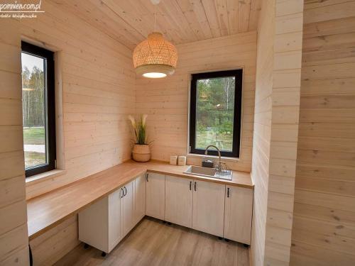 una cocina en una cabaña de madera con fregadero y 2 ventanas en PolanaKubicy,pl, en Nowe Miasto