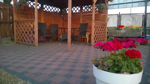 a patio with a table and flowers in a pavilion at Pokoje Gościnne Wejherowo in Wejherowo