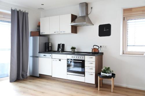 una cucina con armadi bianchi e piano cottura di Appartement Burgblick a Harburg