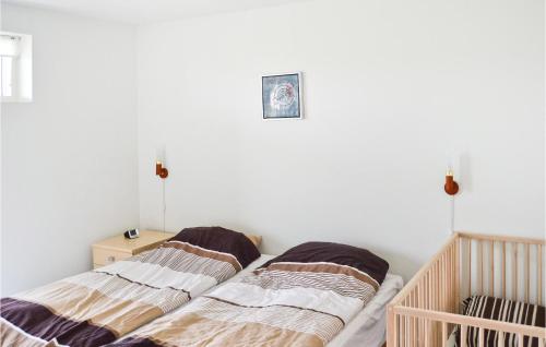 フレデリクスハウンにあるBeautiful Home In Frederikshavn With 3 Bedrooms And Wifiのベッドルーム1室(隣り合わせのベッド2台付)