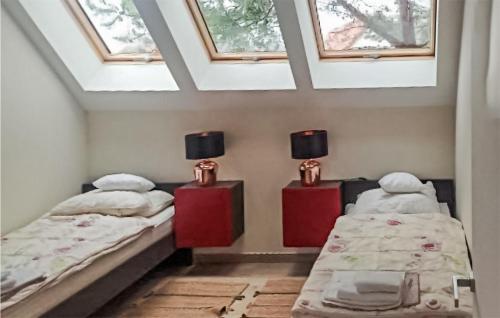 2 camas individuales en una habitación con tragaluces en Beautiful Home In Kowalewo With Wifi And 3 Bedrooms, en Kowalewo