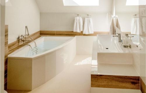 Baño blanco con bañera y lavamanos en Beautiful Home In Kowalewo With Wifi And 3 Bedrooms, en Kowalewo