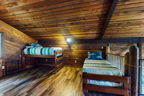 um quarto com duas camas num chalé de madeira em The Coffee Grounds em Johnson Landing
