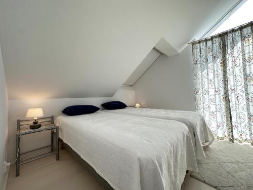 ein Schlafzimmer mit einem Bett mit blauen Kissen und einem Fenster in der Unterkunft Unique holiday home 10 meters from the water at Lilla Fjellsholmen in Kärna