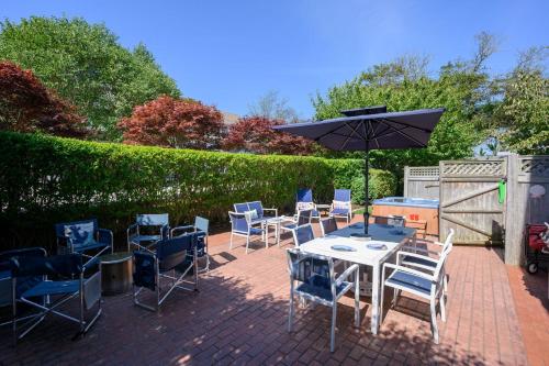 a patio with a table and chairs and an umbrella at 201 Main Street Chatham Cape Cod - - Sandpiper in Chatham