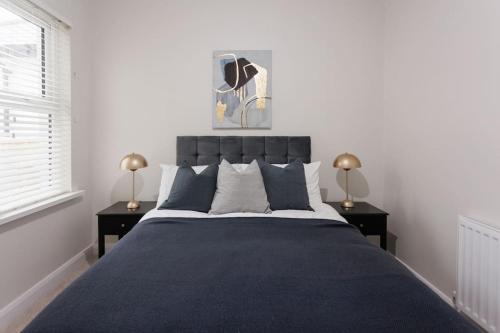 una camera da letto con un grande letto con due comodini di The Views Cottage a Newcastle