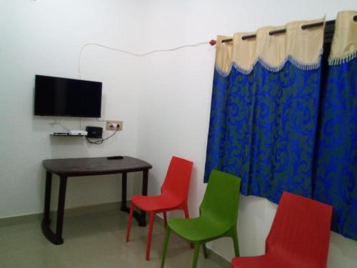 um quarto com quatro cadeiras, uma mesa e uma televisão em Nithin homestay, private 3bedrooms house,madikeri em Madikeri
