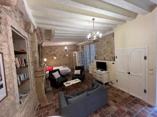 een woonkamer met een bank en een slaapkamer bij Studio Bardin in La Charité-sur-Loire