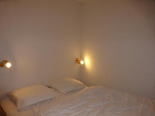 Bett in einem Zimmer mit zwei Kissen darauf in der Unterkunft Appartement Méribel, 2 pièces, 4 personnes - FR-1-411-739 in Les Allues