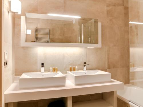 La salle de bains est pourvue de 2 lavabos, d'un miroir et d'une baignoire. dans l'établissement Appartement Courchevel 1550, 5 pièces, 8 personnes - FR-1-562-13, à Courchevel