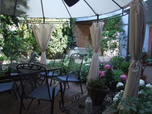 a patio with tables and chairs under an umbrella at Schönbachhof in Silz