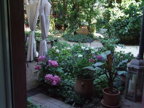 an outdoor garden with flowers and an umbrella at Schönbachhof in Silz