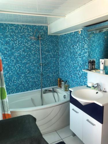 a bathroom with a bath tub and a sink at MAISON DES LILAS in Bellerive-sur-Allier