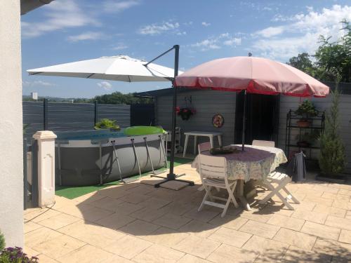 a patio with a table and an umbrella at MAISON DES LILAS in Bellerive-sur-Allier