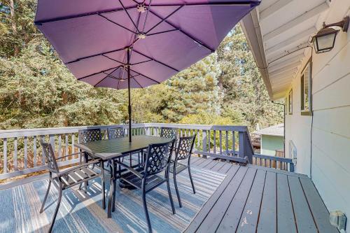 a table and chairs on a deck with an umbrella at Rowandale in University Place