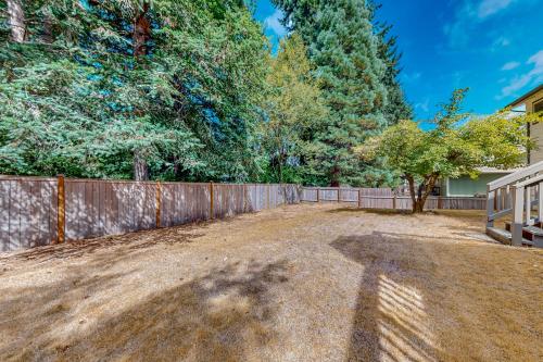an empty yard with a fence and trees at Rowandale in University Place