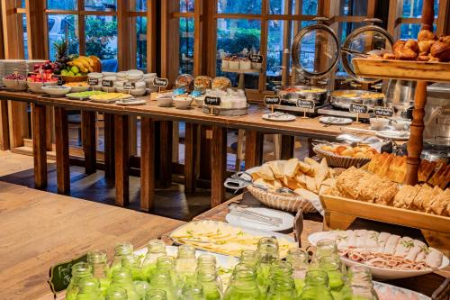 ein Buffet mit Speisen auf einem Tisch mit Brot und Gebäck in der Unterkunft GHL Hotel Bioxury in Bogotá