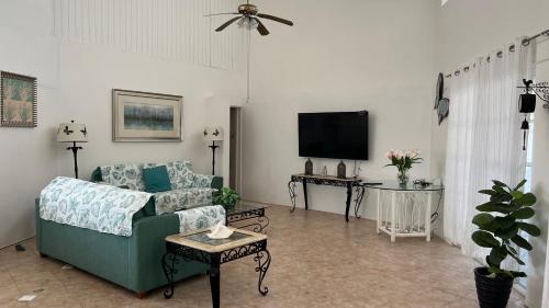 a living room with a couch and a tv at Tu Casita en Aruba in Palm-Eagle Beach