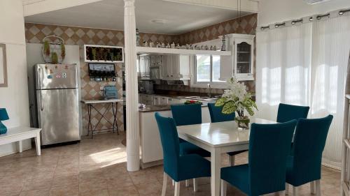 a kitchen and dining room with a table and blue chairs at Tu Casita en Aruba in Palm-Eagle Beach